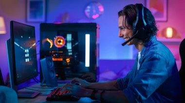 Heyecanlı Oyuncu Onun Kişisel Bilgisayarda First-Person Shooter Online Video Oyunu Playing. Oda ve Pc Renkli Neon Led Işıklar var. Genç Adamın Uzun Saçları Var. Evde Rahat Akşam.