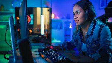 Kulaklık Pretty ve Heyecanlı Siyah Blogger Girl Onun Bilgisayarda First-Person Shooter Online Video Oyunu Oynuyor. Oda ve Pc Renkli Neon Led Işıklar var. Evde Rahat Akşam.