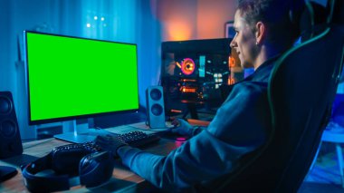 Heyecanlı Oyuncu Onun Güçlü Kişisel Bilgisayar da Bir Mock Up Yeşil Ekran ile Online Video Oyunu Playing. Oda ve Pc Renkli Neon Led Işıklar var. Evde Rahat Akşam.