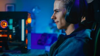 Mutlu Oyun ve Blogger Kulaklık bir Mic Playing Shooter Online Video Oyunu ile Onun Kişisel Bilgisayar. Oda ve Pc Renkli Neon Led Işıklar var. Evde Rahat Akşam.