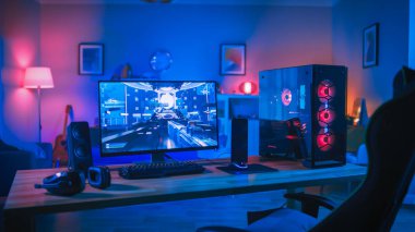 Ekranda First-Person Shooter Oyunu ile Güçlü Kişisel Bilgisayar Gamer Rig. Monitör Evde Masada Duruyor. Modern Tasarımlı Rahat Oda Pembe Neon Işıkla Aydınlatıldı.