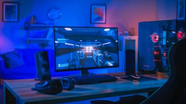 Ekranda First-Person Shooter Oyunu ile Güçlü Kişisel Bilgisayar Gamer Rig. Monitör Evde Masada Duruyor. Modern Tasarımlı Rahat Oda Mavi ve Neon Işıkla Aydınlatıldı.