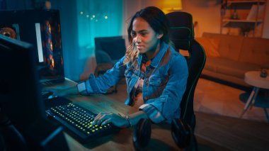 Heyecanlı ve Pretty Black Gamer Girl Onun Kişisel Bilgisayar online video oyunu oynuyor. Oda ve Pc Renkli Sıcak Neon Led Işıklar var. Evde Rahat Akşam.