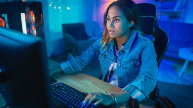 Heyecanlı ve Pretty Black Gamer Girl Onun Kişisel Bilgisayar online video oyunu oynuyor. Oda ve Pc Renkli Soğuk Neon Led Işıklar var. Evde Rahat Akşam.