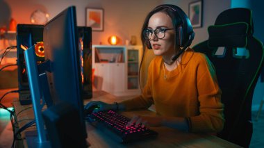 Excited Gamer Girl in Headset with a Mic Playing Online Video Game on Her Personal Computer. She Talks to Other Players. Room and PC have Colorful Warm Neon Led Lights. Cozy Evening at Home. clipart