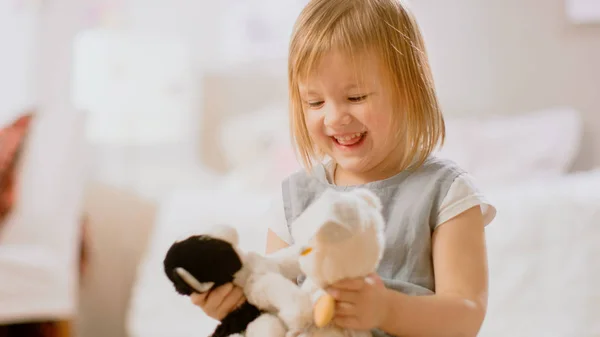 Nella stanza dei bambini: Carina bambina felice che gioca con la casa delle bambole e si siede su un tappeto. Soggiorno soleggiato con bambini che si divertono . — Foto Stock
