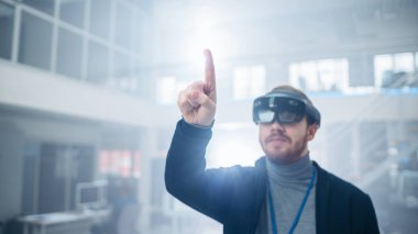 Otomotiv Mühendisi Artırılmış Gerçeklik Kulaklık kullanarak ve Havada Sanal Nesnelerin Dokunaklı Jestler yapma. Fütüristik Atmosfere Sahip İnovasyon Yüksek Teknoloji Laboratuvar Tesisinde.