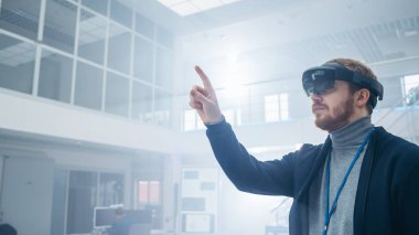 Otomotiv Mühendisi Artırılmış Gerçeklik Kulaklık kullanarak ve Havada Sanal Nesnelerin Dokunaklı Jestler yapma. Fütüristik Atmosfere Sahip İnovasyon Yüksek Teknoloji Laboratuvar Tesisinde.