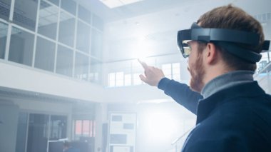 Otomotiv Mühendisi Artırılmış Gerçeklik Kulaklık kullanarak ve Havada Sanal Nesnelerin Dokunaklı Jestler yapma. Fütüristik Atmosfere Sahip İnovasyon Yüksek Teknoloji Laboratuvar Tesisinde.