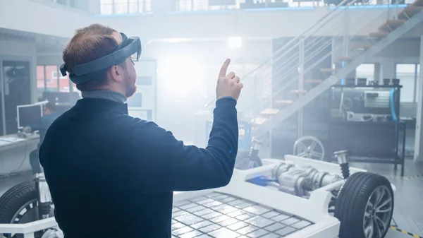 Ingénieur automobile utilisant un casque de réalité augmentée et faisant des gestes touchants d'un bouton virtuel dans l'air. En innovation Laboratoire de haute technologie avec atmosphère futuriste . — Photo