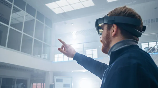 Ingénieur automobile utilisant un casque de réalité augmentée et faisant des gestes touchants d'objets virtuels dans les airs. En innovation Laboratoire de haute technologie avec atmosphère futuriste . — Photo