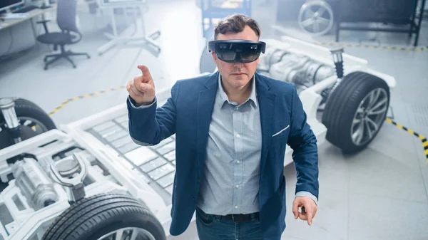 Otomotiv Mühendisi Artırılmış Gerçeklik Kulaklık Kullanarak Dokunma hareketleri yapma. Yenilik Laboratuvarı Nda Tesis Konsept Araç Çerçevesi Tekerlekler, Süspansiyon, Motor ve Akü.