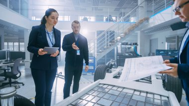 Otomotiv Tasarım Mühendisleri Elektrikli Araç Şasi Prototipi Üzerinde Çalışırken Konuşuyor. Yenilik Laboratuvarı Nda Tesis Konsept Araç Çerçevesi Tekerlekler, Süspansiyon, Motor ve Akü.