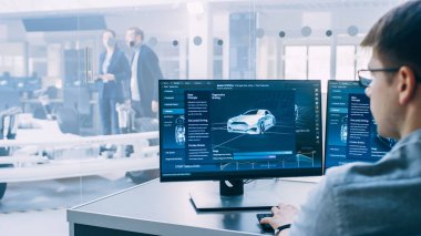 Profesyonel Mühendis 3d Cad Yazılımı ile Bir Bilgisayarda Çalışır ve Yüksek Teknoloji Geliştirme Laboratuvarı'nda Tekerlekler, Piller ve Motor Ayakta Elektrikli Araba Şasi Prototip Testleri.