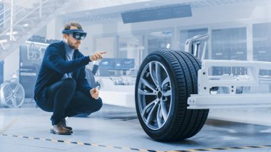 Otomotiv Mühendisi Elektrikli Otomobil Şasi Platformu üzerinde çalışıyor, Artırılmış Gerçeklik Kulaklık kullanarak. Yenilik Laboratuvarı Nda Tesis Konsept Araç Çerçevesi Tekerlekler, Süspansiyon, Motor ve Akü.