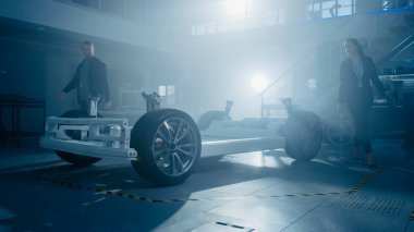 Otomotiv İnovasyon Tesisi Otomobil Tasarım Mühendisleri Ekibi. Onlar Tekerlekler, Süspansiyon, Hibrid Motor ve Pil içeren Elektrikli Otomobil Platformu Şasi Prototip üzerinde çalışıyoruz.