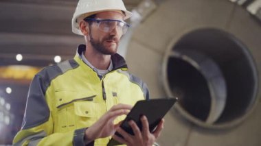 Güvenlik Üniforması Giyen Profesyonel Ağır Sanayi Mühendisi / İşçi Portresi ve Tablet Bilgisayar Kullanıyor. Petrol, Gaz ve Yakıt Taşıma Boru Hattı Arkaplan İnşaat Fabrikasında