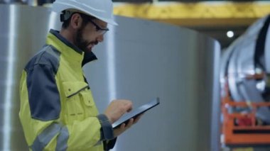 Ağır Sanayi Mühendisi Boru İmalat Fabrikası'nda Yürüyün, Dijital Tablet Bilgisayar Kullanın. Petrol, Gaz ve Akaryakıt Boru Hattı Taşıma Ürünleri İnşaatı Tesisi. Yan Görünüm Yavaş Hareket