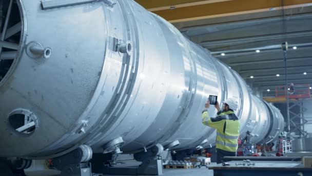 Heavy Industry Engineer Uses Augmented Reality Digital Tablet to Scan Large Diameter Pipe. Modern Industrial Manufacturing Technology to Design and Construct Oil, Gas and Fuels Transport Pipeline. — Stock Video