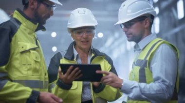 Üç Ağır Sanayi Mühendisi Boru İmalat Fabrikası 'nda duruyor, Dijital Tablet Bilgisayar kullanın, Tartışıyorlar. Büyük Boru Birleştirildi. Petrol, Gaz ve Yakıt Taşıma Boruhattının Tasarımı ve Yapımı