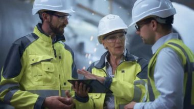 Üç Ağır Sanayi Mühendisi Boru İmalat Fabrikası 'nda duruyor, Dijital Tablet Bilgisayar kullanın, Tartışıyorlar. Büyük Boru Birleştirildi. Petrol, Gaz ve Yakıt Taşıma Boruhattının Tasarımı ve Yapımı