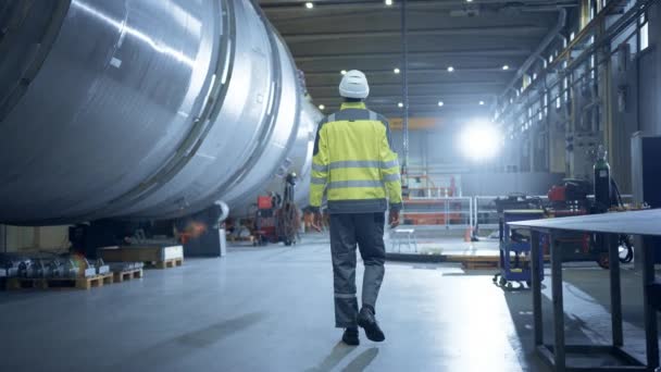Following Shot of Heavy Industry Engineer Walking through Pipe Manufacturing Factory. Modern Facility for Design and Construction of Large Diameter Oil, Gas and Fuels Transport Pipeline. Slow Motion — Stock Video