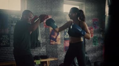 Fit Atletik Kadın Kickboxer Punches ve Bir Loft Spor Salonu'nda bir egzersiz sırasında Punching Pedleri Hits. Çok güzel ve enerjik. Güçlü Koç Boks Pedleri tutuyor. Yoğun Kendini Savunma Eğitimi.