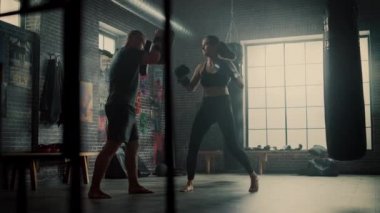 Fit Atletik Kadın Kickboxer Punches Spor Salonu'nda bir egzersiz sırasında Punching Pedleri. Çok güzel ve enerjik. Güçlü Koç Boks Pedleri tutuyor. Yoğun Kendini Savunma Eğitimi.