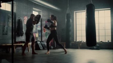 Fit Atletik Kadın Kickboxer Punches Spor Salonu'nda bir egzersiz sırasında Punching Pedleri. Çok güzel ve enerjik. Güçlü Koç Boks Pedleri tutuyor. Yoğun Kendini Savunma Eğitimi.