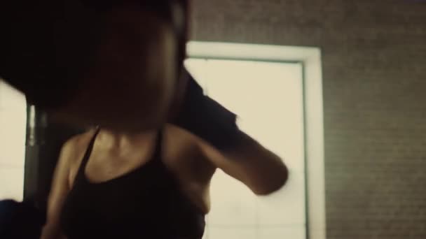 Fit Athletic Woman Kickboxer golpea y golpea las almohadillas de perforación durante un entrenamiento en un gimnasio loft. Es hermosa y enérgica. El entrenador fuerte sostiene las almohadillas de boxeo. Entrenamiento intensivo de autodefensa . — Vídeo de stock