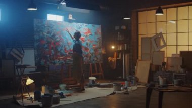 Yetenekli Kadın Sanatçı Modern Soyut Yağlı Boyama, Geniş Vuruşlar Kullanarak Hareketlendirme Boya Fırçası üzerinde çalışıyor. Karanlık Yaratıcı Stüdyo Büyük Resim Easel Aydınlandı, Araçlar Her Yerde