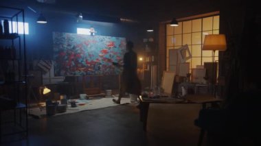 Yetenekli Kadın Sanatçı Modern Soyut Yağ Boyama, Sıçratma ve Damlatma Kullanımı ve Fırça Teknikleri üzerine çalışıyor. Dark Credio Studio Large Picture Stands on Easel Aydınlanmış. Yavaş Hareket