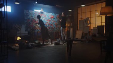 Sanat Sınıfında: Yetenekli Genç Kadın Sanatçı Büyük Tuval üzerine bir Fırça ile Boyalar, Tanınmış Ressam Stilleri Hakkında Ona Öğretir. Renk ve Duygularla Dolu Büyük Parlak Resimli Karanlık Stüdyo