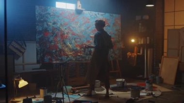 Yetenekli Kadın Sanatçı Enerjik Boya Fırçası ile Çizer, O Yağlıboya Modern Masterpiece oluşturur. Çarpıcı Renkler Büyük Tuval ile Yaratıcı Stüdyo. Uzaklaştırma Yı Takip Edin