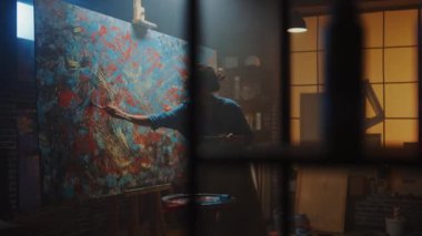 Boya Fırçası Ile Enerjik ve Coşkulu Çizim Yetenekli Kadın Sanatçı, O Yağlıboya Modern Masterpiece oluşturur. Büyük Tuval ile Yaratıcı Stüdyo. Yan Görünüm Ark Çekimi
