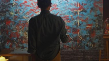 Yetenekli Kadın Sanatçı Enerjik Boya Fırçası Kullanarak O Yağlıboya Modern Masterpiece oluşturur. Koyu Yaratıcı Stüdyo nerede Büyük Tuval Easel Işıklı duruyor. Çekimden Sonra Geri Görünüm