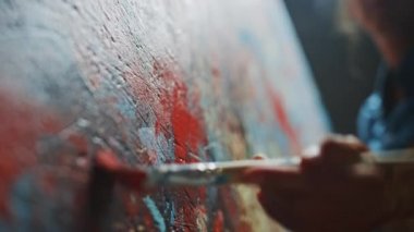 Ressam Eli 'nin yakın çekimi, Fırça Tutma ve Kırmızı Boyayla Çizim. Renkli, Duygusal Yağlı Boyama. Çağdaş Ressam Modern Soyut Sanat Parçası Oluşturuyor