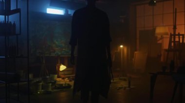 Kendine güvenen ve Kararlı Kadın Sanatçı Tuval için Walks ve Modern Soyut Yağlıboya Resim Başlar. Yaratıcı Studio Büyük Resim Easel Işıklı duruyor. Geri Görünüm Çekimini Takip Edin