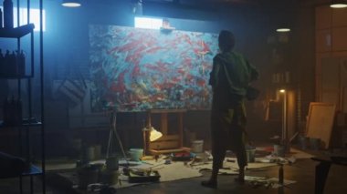 Yetenekli Kadın Sanatçı Soyut Yağlıboya Üzerine Çalışıyor, Geniş Boya Fırçası Vuruşlarıyla Modern Başyapıt ı Yaratıyor. Koyu ve Dağınık Yaratıcı Stüdyo nerede Büyük Tuval Easel Işıklı Standları