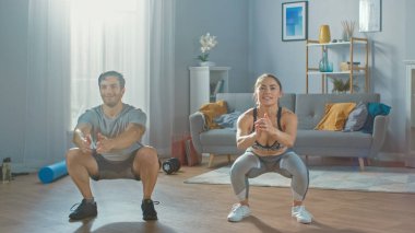 Kas Atletik Adam ve Egzersiz Giysiler igüzel Fitness Woman Minimalist İç ile Onların Parlak ve Geniş Daire Squat Egzersizleri yapıyoruz.