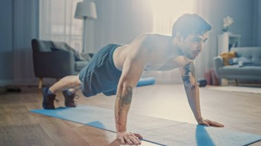 Güçlü Athletic Fit Gömleksiz Adam Minimalist İç ile Onun Geniş ve Parlak Oturma Odasında Push Ups yapıyor.