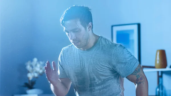 Bliska silnego Athletic Fit Man w T-shirt skoncentrowany na energetycznym jogging w domu w swoim przestronnym i jasnym mieszkaniu z minimalistycznym wnętrzem. Strzał w niebieskie światło. — Zdjęcie stockowe