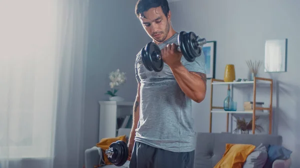 Strong Athletic Fit Man in T-shirt and Shorts is Doing Calf Raise Exercises with Dumbbells at Home in His Spacious and Bright Apartment with Minimalist Interior. — Φωτογραφία Αρχείου