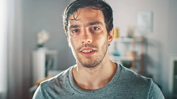 Sweating Muscular Athletic Fit Man in Grey Outfit is Posing After a Workout at Home in His Spacious and Sunny Living Room with Minimalistic Interior. — Stock Photo, Image