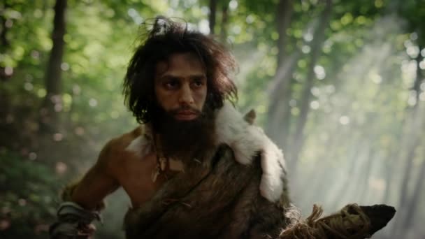 Retrato de Caveman Primeval vestindo pele de animal e caça à pele com uma lança de pedra na floresta pré-histórica. Caçador Neandertal Pré-histórico Pronto para Jogar Lança na Selva — Vídeo de Stock