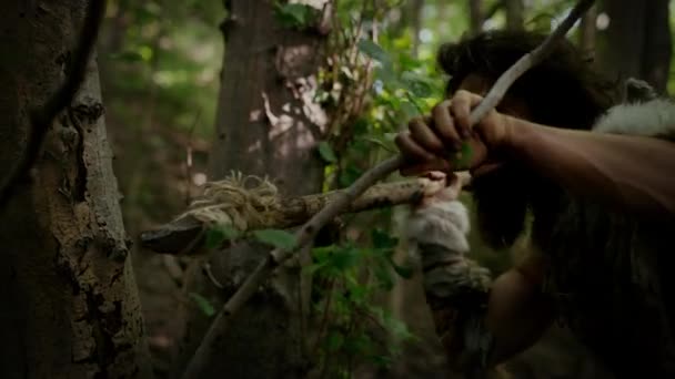 Retrato de Caveman Primeval vestindo pele de animal e caça à pele com uma lança de pedra na floresta pré-histórica. Caçador Neandertal Pré-histórico Pronto para Jogar Lança na Selva — Vídeo de Stock