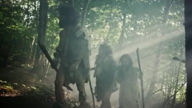 Hayvan Derisi Tutma Taşı Taşı Giyen Avcı-Toplayıcılar kabilesi Hayvan Avı Avında Tarih Öncesi Ormanı Keşfeder. Ormanda Neandertal Aile Avı ya da Daha İyi Topraklar İçin Göç