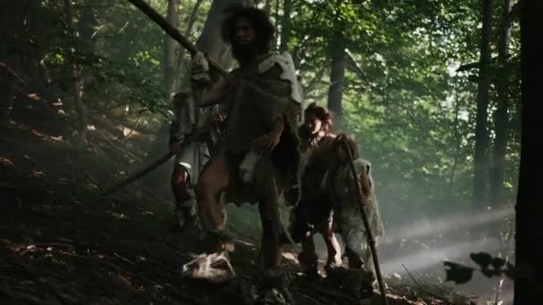 Tribe of Hunter-Gatherers Wearing Animal Skin Holding Stone Tipped Tools, Explore Prehistoric Forest in a Hunt for Animal Prey. Neanderthal Family Hunting in the Jungle or Migrating for Better Land — Stock Video