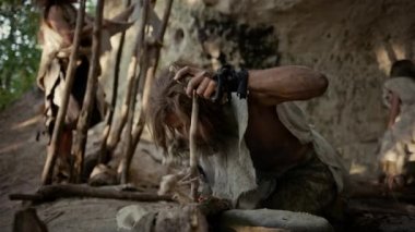 Primeval Caveman Bow Matkap Yöntemi ile Yangın yapmaya çalışıyor Hayvan Deri Giyen. İnsan Uygarlığı Tarihinde Neandertal Kindle İlk İnsan Yapımı Ateş. Yemek Pişirmek için Ateş Yapmak. Yavaş Çekim