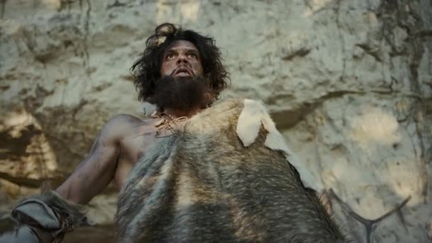 Portrait of Primeval Caveman Wearing Animal Skin Does Threatening Chest Beating and Screaming, Defending His Cave and Territory in the Prehistoric Times (en inglés). Líder Neandertal Prehistórico o Homo Sapiens — Vídeo de stock